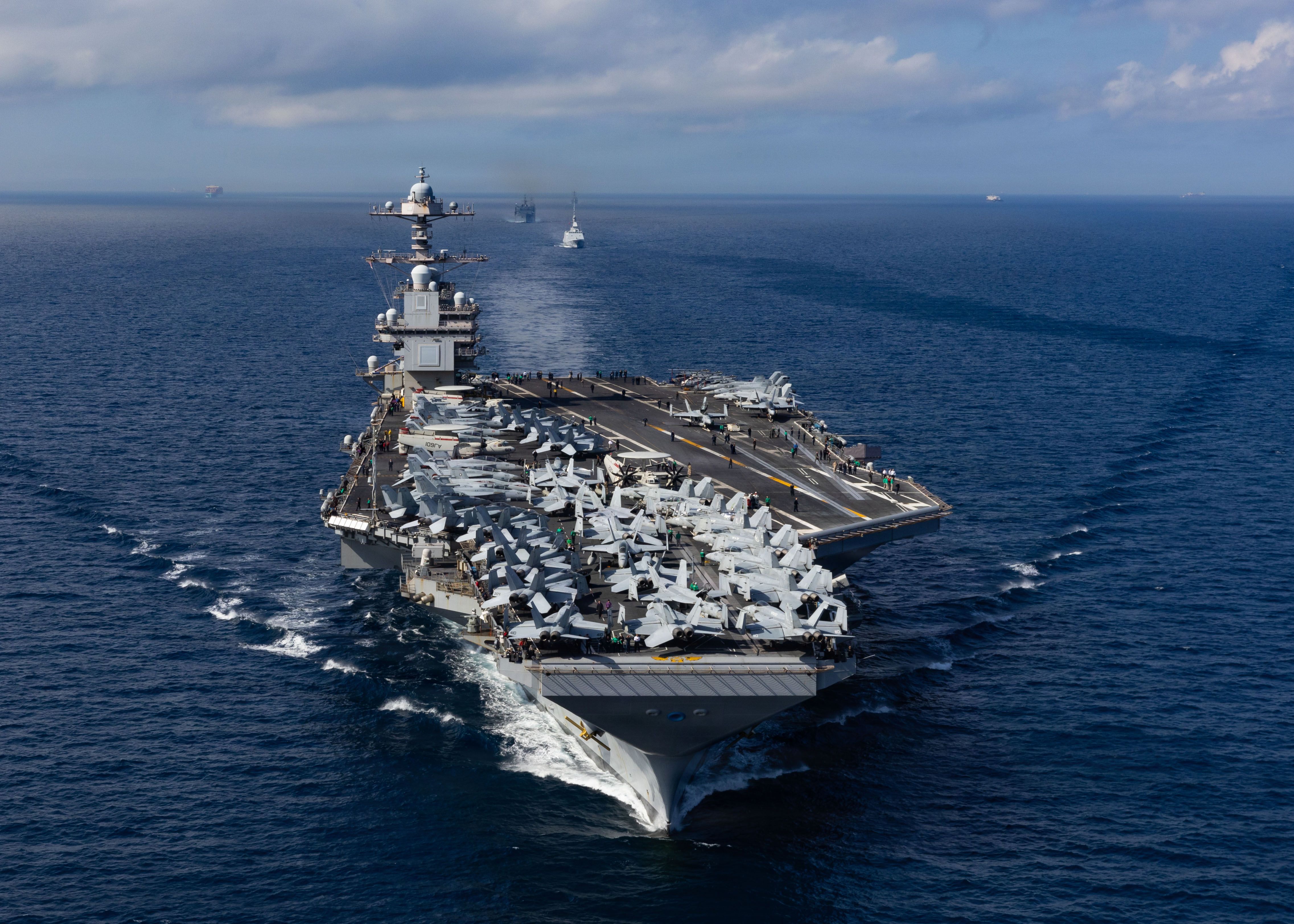 A U.S. Navy aircraft carrier with a full flight deck underway at sea